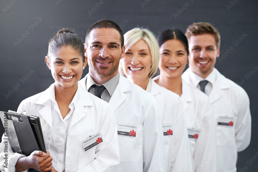 Smile, portrait and row of doctors in studio for health insurance, medicine and trust in hospital. Confidence, group and diversity with men, women and professional medical team on grey background