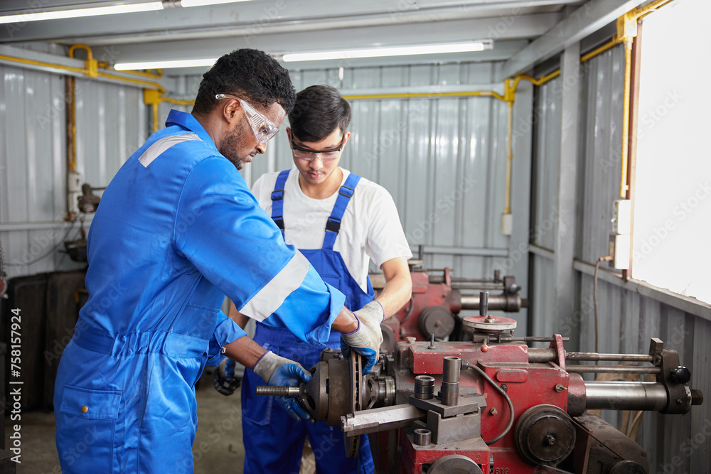 factory workers or technicians working and control lathe machine in factory