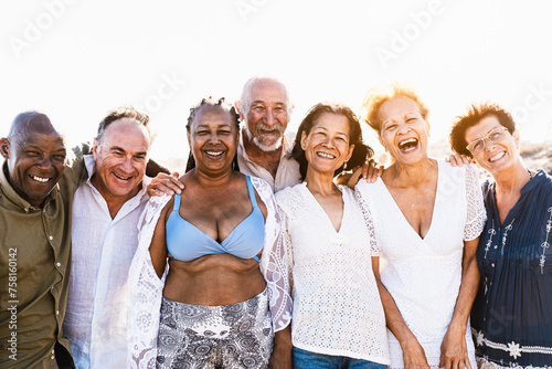 Happy multiracial senior friends having fun smiling into the camera on the beach - Diverse elderly people enjoying summer holidays