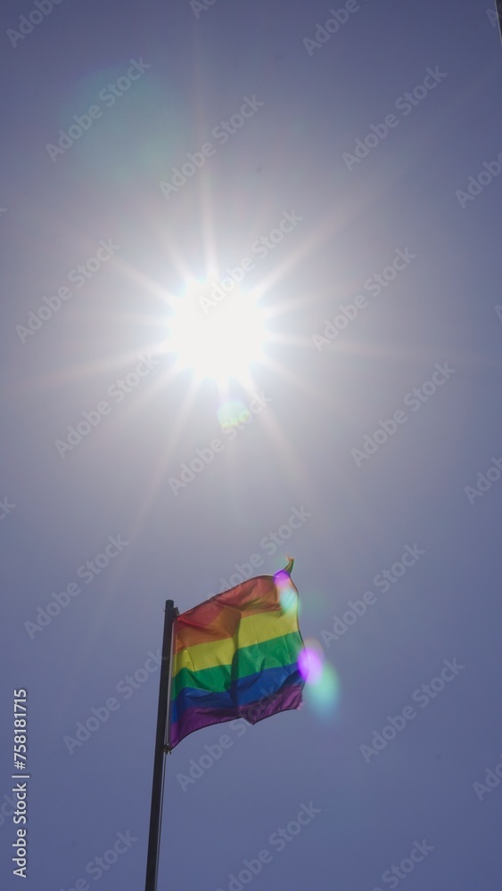 Rainbow colored gay flag illuminated by sunbeam