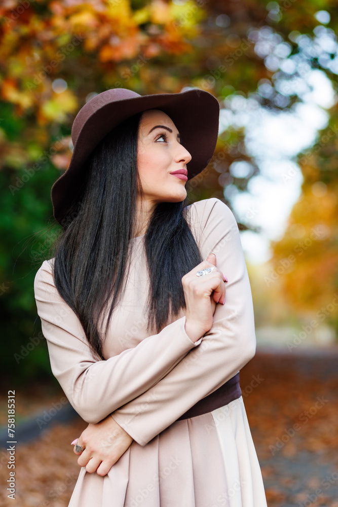 A stylish woman in wide-brimmed hat and beige coat enjoying the season s splendor