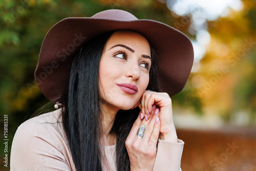 Obraz na płótnie Closeup of young woman in a beige coat and hat enjoying the vibrant colors of the season. w salonie