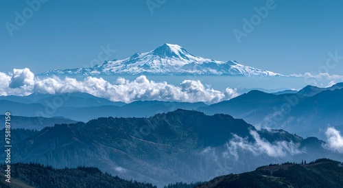 Mount Rainier Majesty: Snow-Capped Peak Amid Swirling Clouds and Dense Forests Under a Clear Blue Sky © Pierre