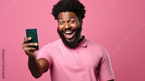 A young man stands surprised with a phone on a colored monotone background