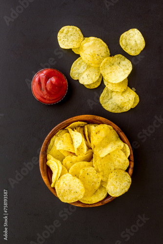 Homemade low calorie crispy potato chips in bowl, top view