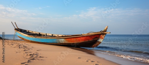 Lone Boat Rests on Sandy Shoreline, Embraced by Calm Ocean Waves and Serene Coastal Beauty