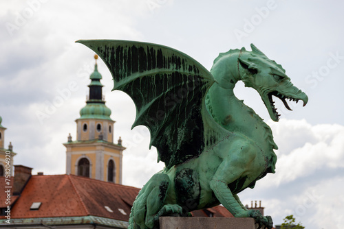 Ljubljana, Slovenia; The Ljubljana Dragon Bridge spans the Ljubljanica River, Ljubljana Central Market and Saint Nicholas's Cathedral (Katedrala Sv. Nikolaj), dragon sculpture