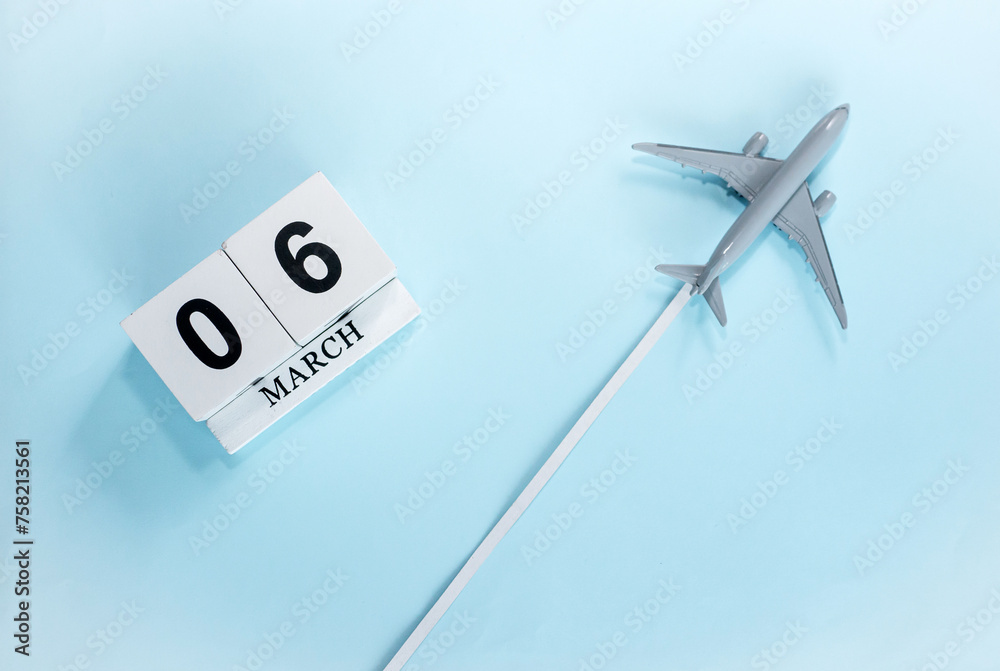March calendar with number 6. Top view of a calendar with a flying passenger plane. Scheduler. Travel concept. Copy space. March calendar with number 6. Top view of a calendar with a flying passenger plane. Scheduler. Travel concept. Copy space.