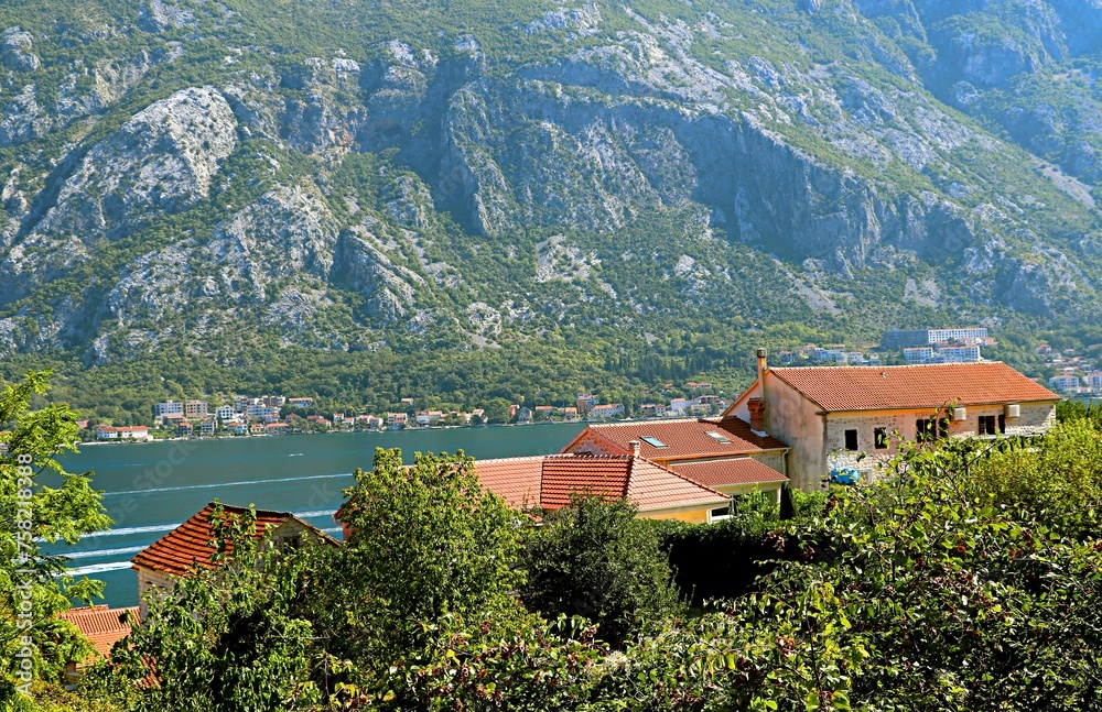 View of the mountains and the Bay of Kotor over the tiled roofs of old houses
