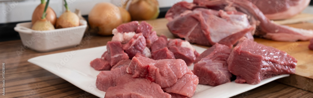 Peases of meat, cutting fresh raw meat on board in white kitchen. Banner, Preparing pork meat, cooking Peases of meat, cutting fresh raw meat on board in white kitchen. Banner, Preparing pork meat, cooking