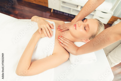 Caucasian woman customer enjoying relaxing anti-stress spa massage and pampering with beauty skin recreation leisure in day light ambient salon spa at luxury resort or hotel. Quiescent