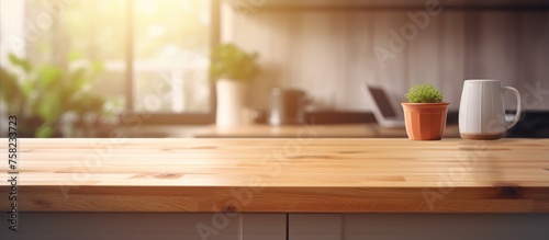 Wooden desk space on a blurred kitchen bench background. © Vusal