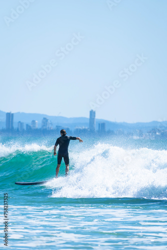 Male surfer training his skills during morning on the beach near the city © Uri Prat