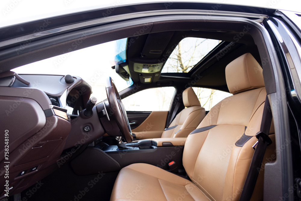 Car interior luxury inside. Steering wheel, dashboard, speedometer, display. Brown leather interior. Modern luxury car Interior - steering wheel, shift lever and dashboard