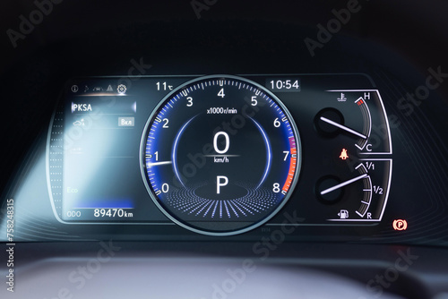 Dashboard of a modern expensive car. The interior of the car. Modern luxury hybrid car interior details. Speedometer and tachometer with additional instruments on car dashboard