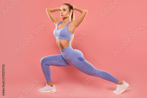 A slender female bodybuilder in a lilac tracksuit does an exercise to burn belly fat and does cardio. Sports concept, fat burning and healthy lifestyle.