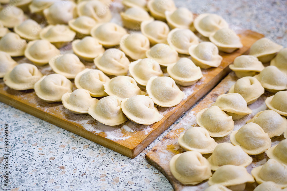 Homemade dumplings close-up. handmade dumplings on a wooden board, selective focus, tinted image, traditional Russian dish, Homemade dumplings close-up. handmade dumplings on a wooden board, selective focus, tinted image, traditional Russian dish,