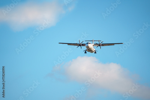 ATR 72 airplane in the air. A twin-engine turboprop short-haul regional passenger aircraft. Landing airplane.