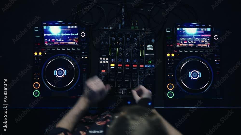 DJ Mixer In Nightclub, Top View, Man Mixing Tracks In Techno And Electronic Music Style DJ Mixer In Nightclub, Top View, Man Mixing Tracks In Techno And Electronic Music Style