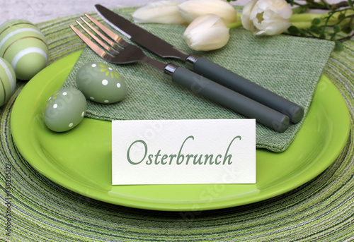 Der Text Osterbrunch mit Osterdekoration und Blumen.