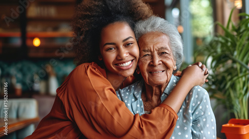 Young woman and an elderly woman closely posing together, smiling warmly, giving a sense of family, affection, and generational connection.