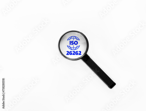 Magnifying glass zooming on ISO26262 Functional Safety sign related to Hazards prevention via Automotive software