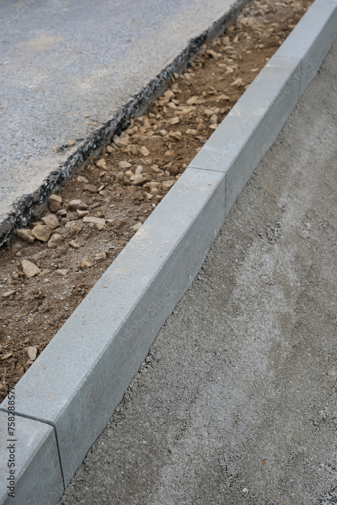 Fototapeta premium Strassenbau, Einbau von Randsteinen aus Beton