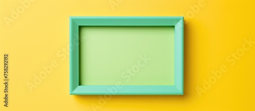 A rectangle electric blue picture frame is displayed on a vibrant yellow background, creating a striking contrast. The symmetry and parallel lines showcase a perfect balance of colors and shapes photo
