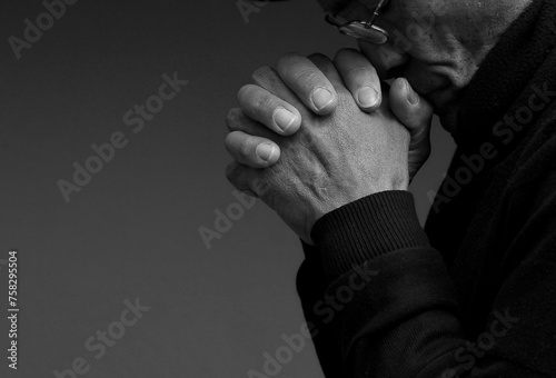 man praying to god with hands together Caribbean man praying stock photo	