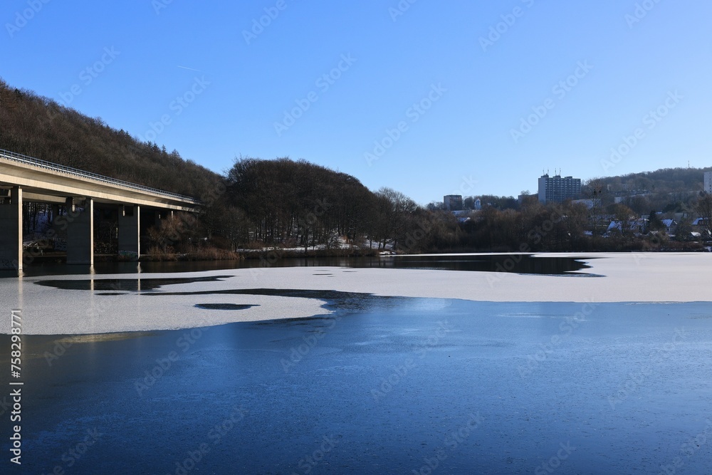 Blick auf die Autobahnbrücke über den zugefrorenen Seilersee in Iserlohn im Sauerland	