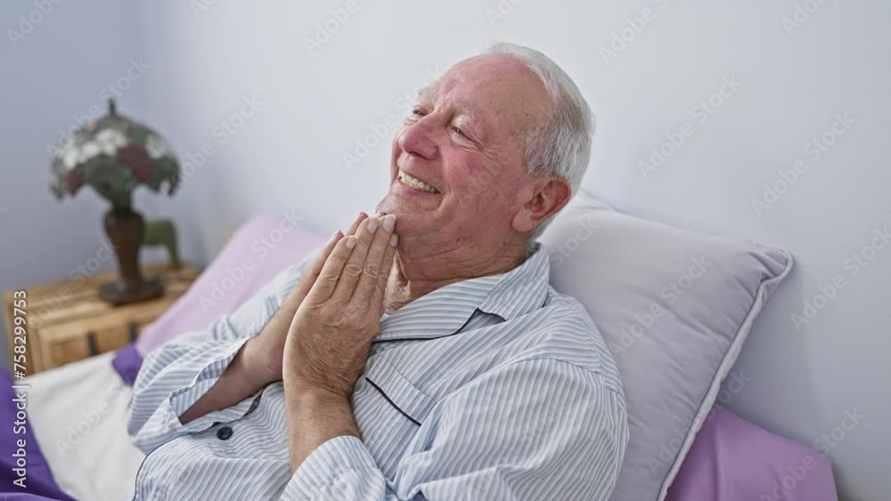 Confident elder man in pyjamas prays for forgiveness on bedroom bed, hands together in faith