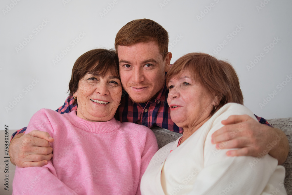 Casual and heartwarming; an adult grandson and his grandmothers bask in each other s company. The image resonates with the joy of family visits. Casual and heartwarming; an adult grandson and his grandmothers bask in each other s company. The image resonates with the joy of family visits.