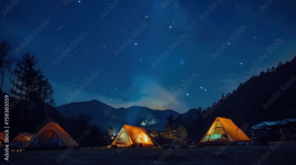 Glowing tents under a starry sky in a mountain campsite