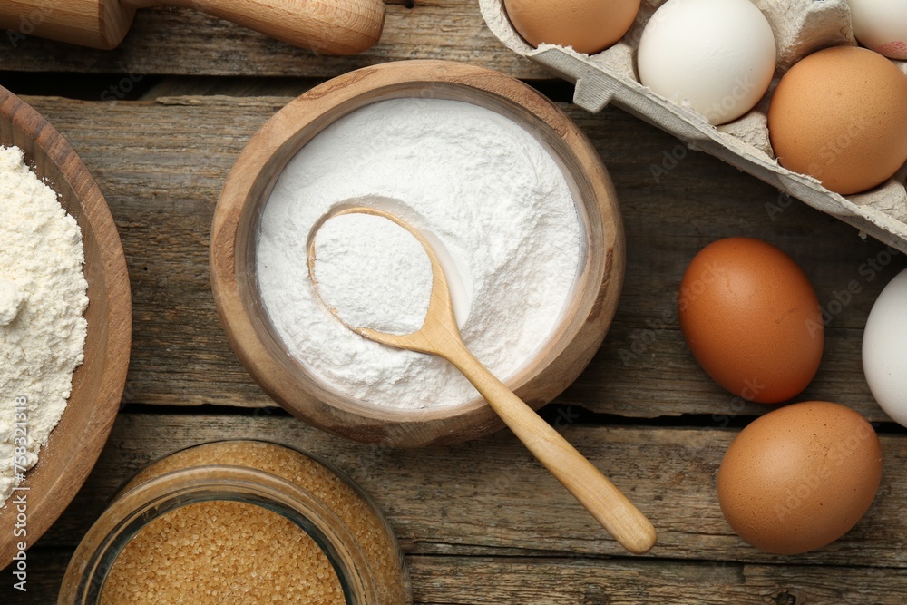 Baking powder, eggs, brown sugar and flour on wooden table, flat lay Baking powder, eggs, brown sugar and flour on wooden table, flat lay