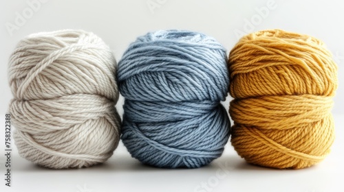 three skeins of skeins of yarn in various shades of blue, yellow, and white on a white background.