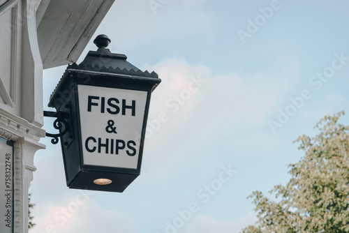 Fish and Chip sign outside a restaurant in London, UK, against sky. photo