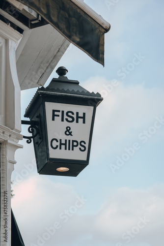 Fish and Chip sign outside a restaurant in London, UK, against sky. photo