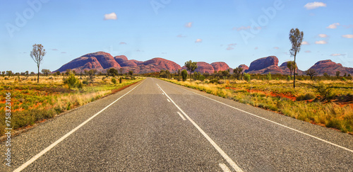 Road heading towards Kata Tjuta aka the Olgas, large domed rock formations in Northern Territory, Central Australia - Inselberg sacred to the Anangu aboriginal people of Australia photo