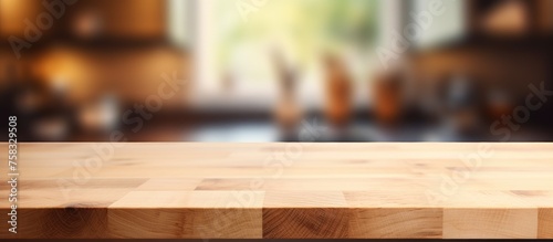 A rectangular wooden table made of hardwood plank with a varnish finish, set against a blurred kitchen background. The wood stain enhances the natural pattern of the lumber © TheWaterMeloonProjec