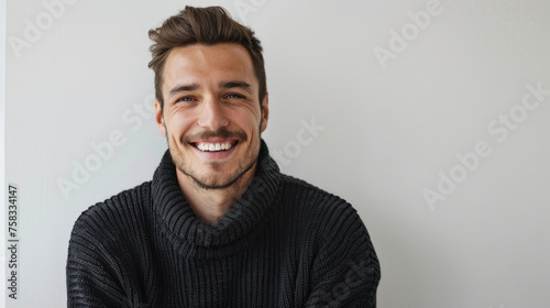 A man in a turtle neck sweater smiling for the camera. Suitable for business or casual concepts
