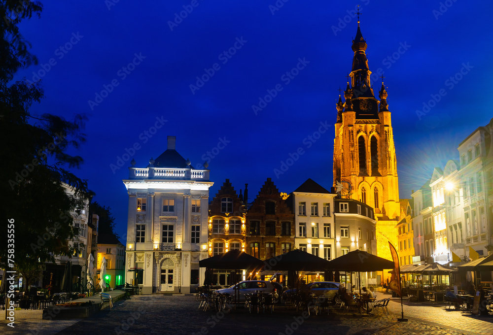 Saint Martin's Church of Kortrijk at dusk, illuminated by city lights. Central Square of Belgian city in West Flanders.
