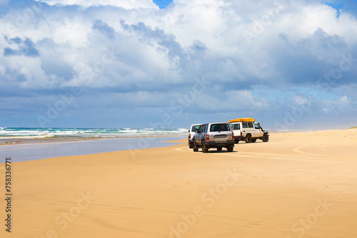 4WD trucks offroad on the Fraser island beach track near Indian Head on the 75 mile beach on the east coast of the island in Queensland, Australia