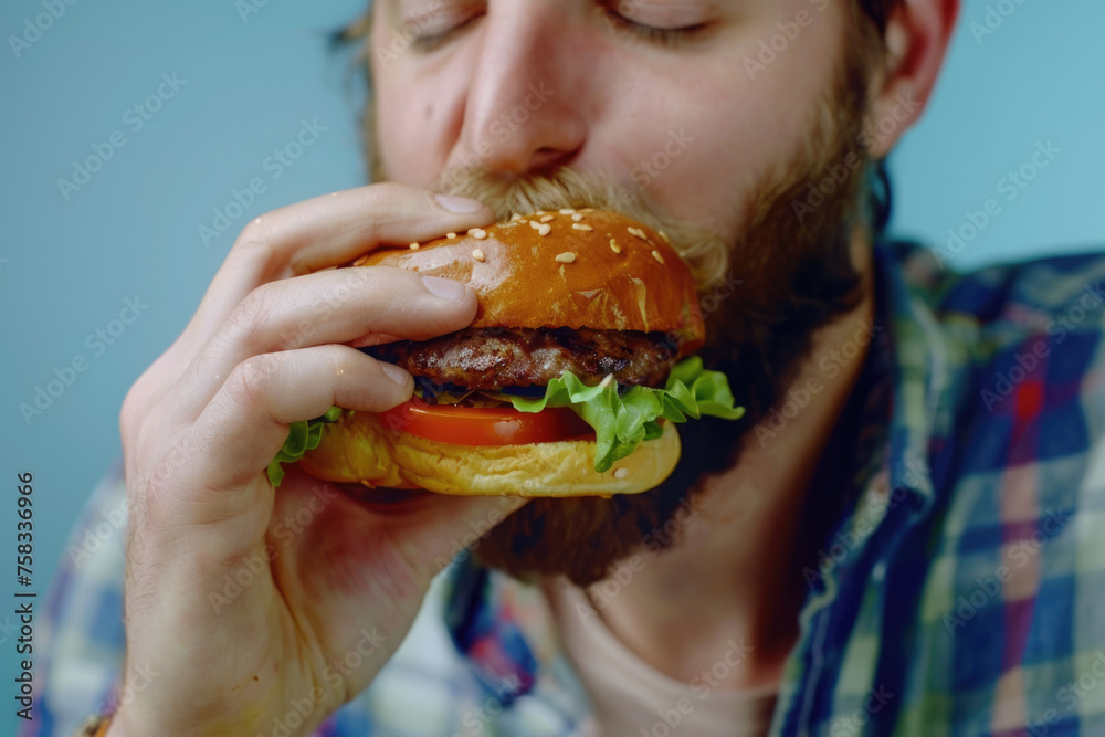 A man enjoying a hamburger with fresh lettuce and tomato, perfect for food-related designs A man enjoying a hamburger with fresh lettuce and tomato, perfect for food-related designs