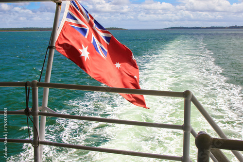 Australian Red Ensign flag on the aft of the Kingfisher Bay ferry, travelling between the east coast of Queensland to Fraser Island (K'gari), the largest sand island in the world located in Australia