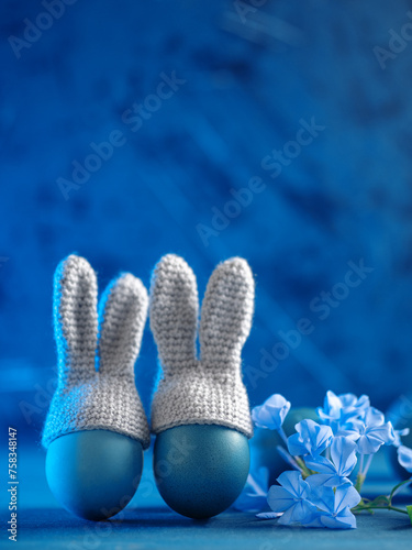 Happy Easter postcard, Easter eggs with bunny ears on a blue background. Copy space