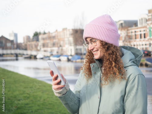 Photography Smiling Young Woman Using Smartphone by the Riverside
