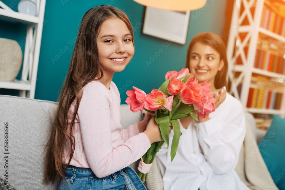 Cute little girl presenting a bouquet of pink tulips to her mother at home. Mother`s day concept Cute little girl presenting a bouquet of pink tulips to her mother at home. Mother`s day concept