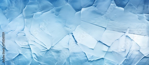 A macro shot of shattered ice revealing intricate patterns on an electric blue background resembling transparent glass. The liquid aqua color pops against the freezing azure backdrop