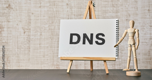 There is notebook with the word DNS. It is an abbreviation for Domain Name System as eye-catching image.