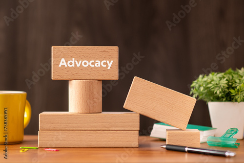 There is wood block with the word Advocacy. It is as an eye-catching image. photo